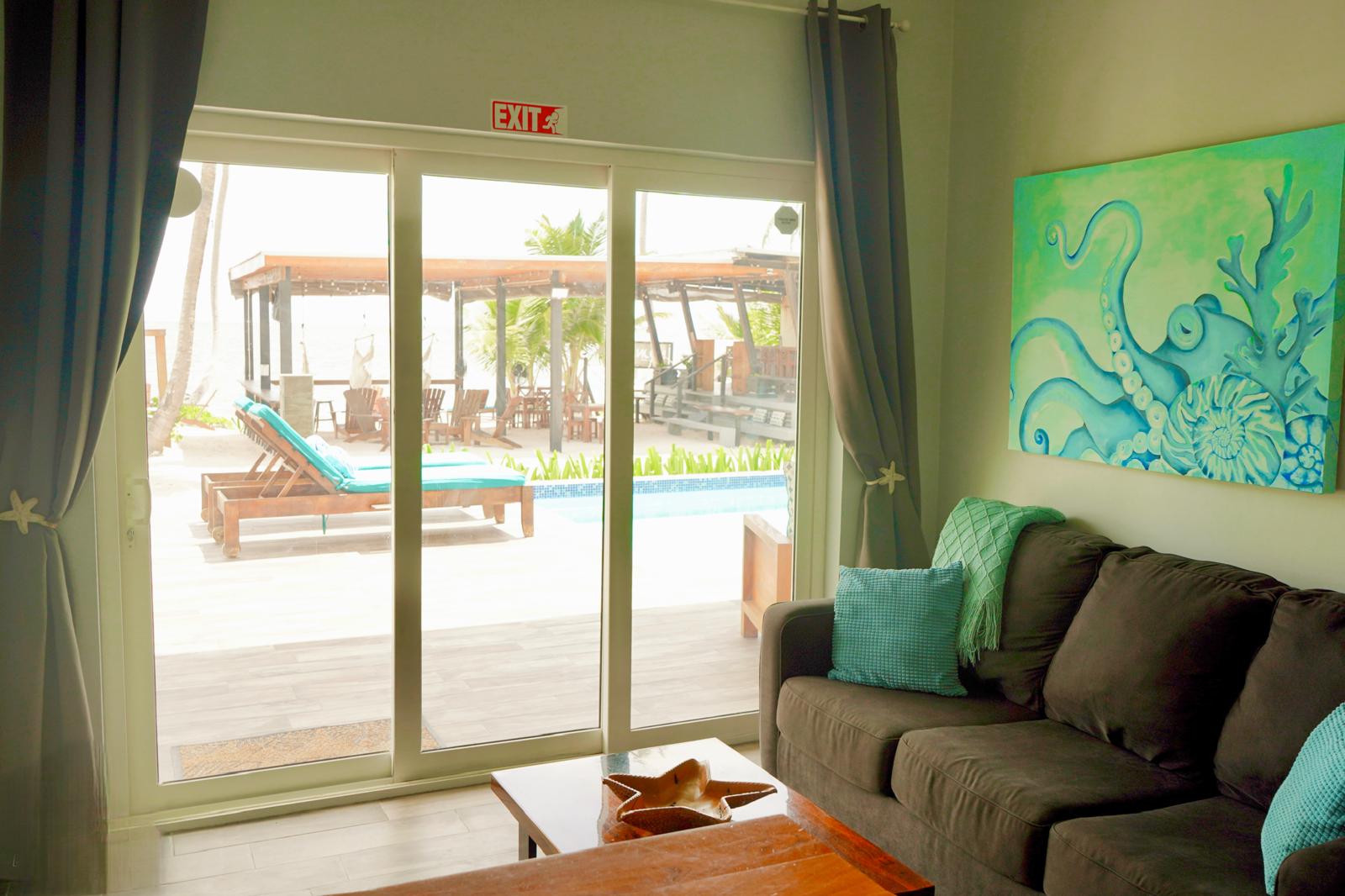 Villa living area showing the view of the pool and beach from the sliding glass door