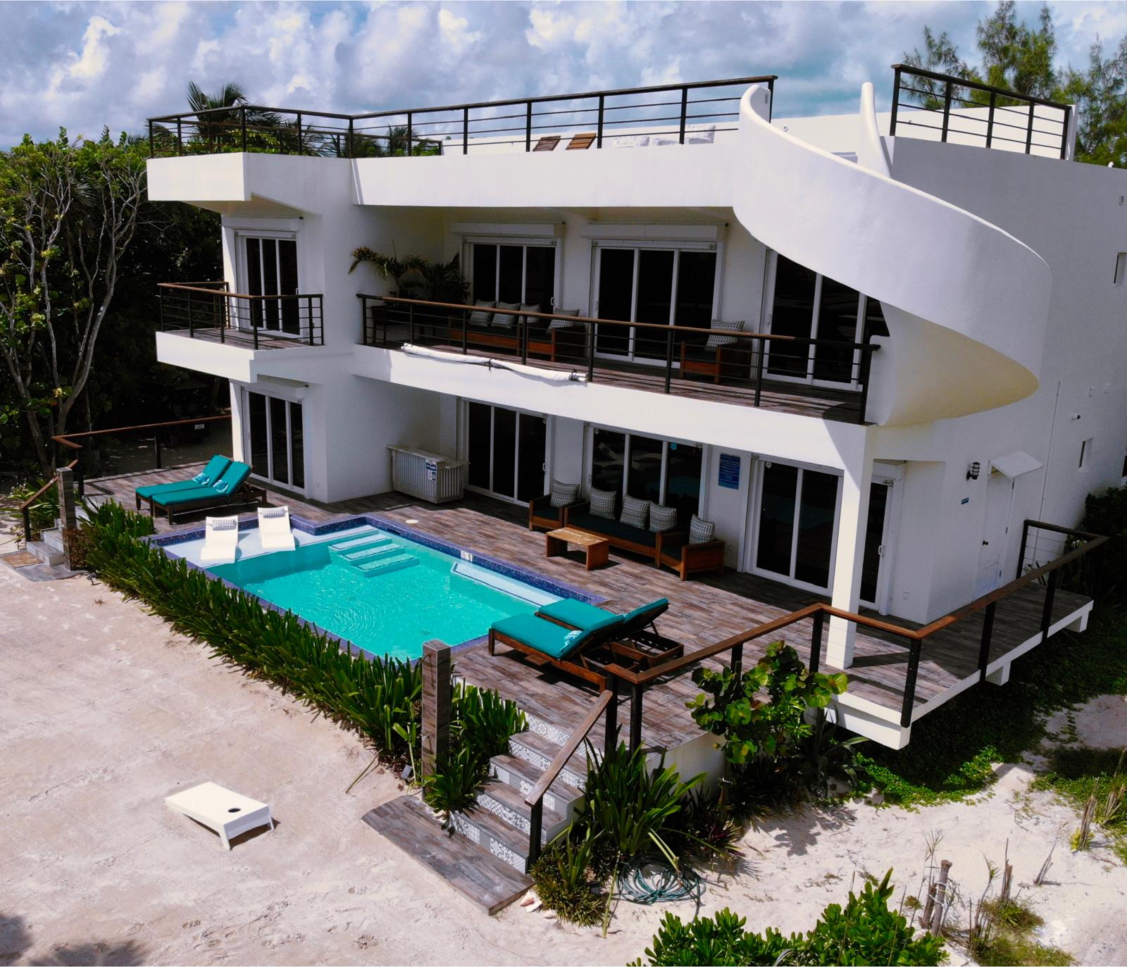 Front of hotel with a pool and lounge chairs