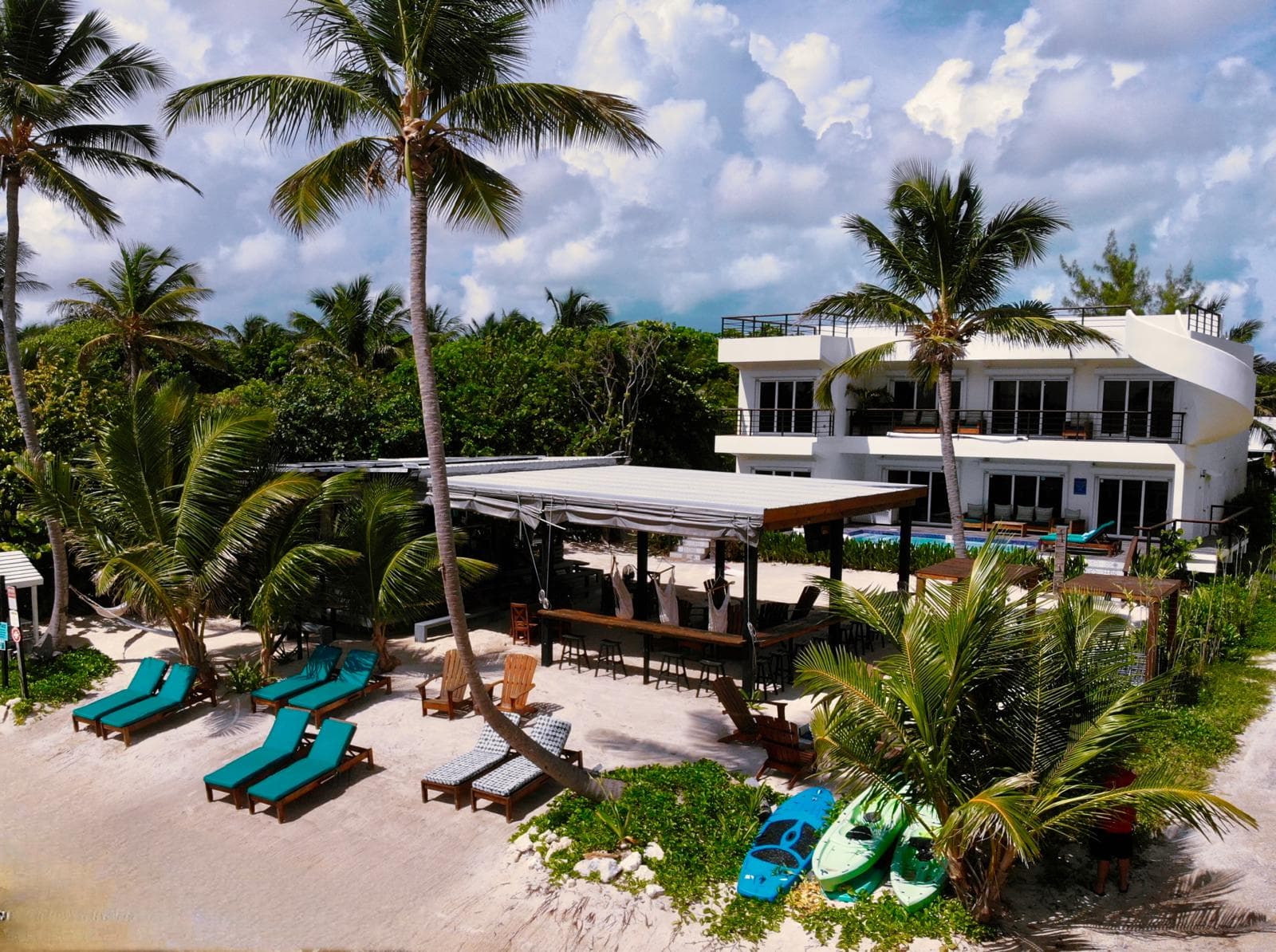 Front of hotel, Moon Bar, and beach with lounge chairs