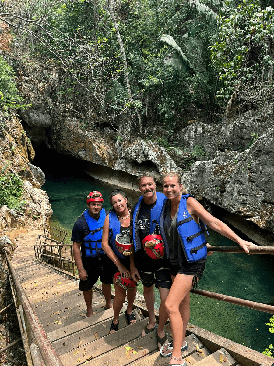 four people standing on stairs above a green river four people standing on stairs above a green river